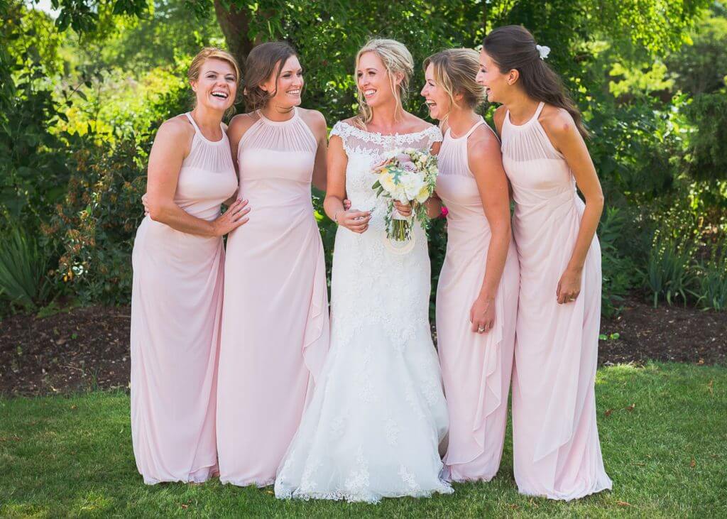 06 laughing bride white dress flowers bouquet with bridesmaids in pink dresses before church marriage ceremony oxfordshre wedding photography