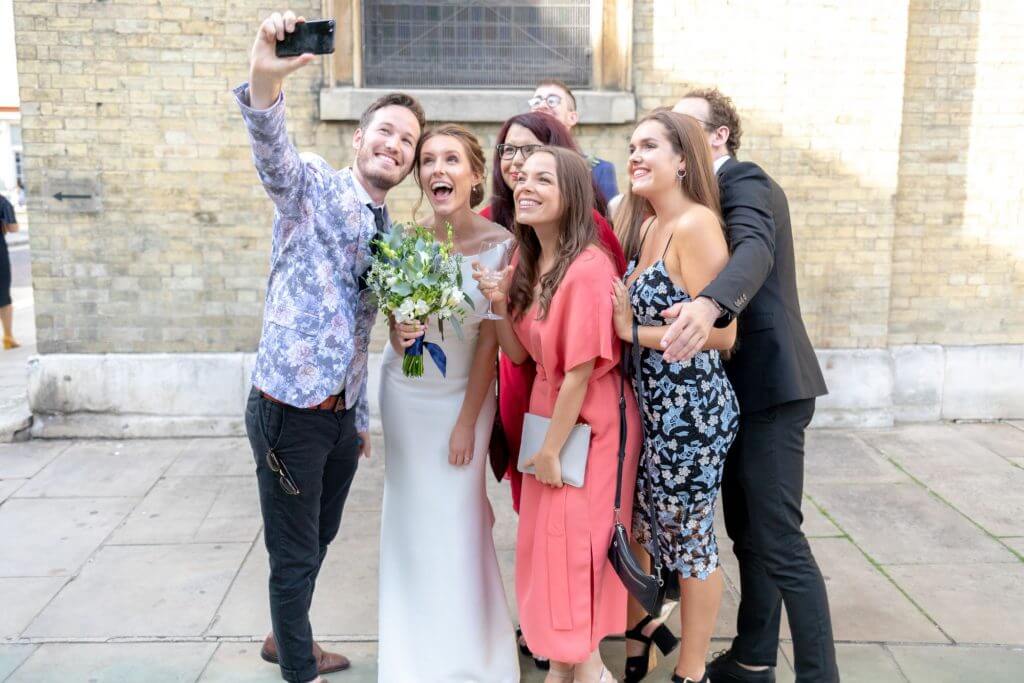 07 bride and guests take selfie after marriage ceremony st bryanston square marylebone london oxfordshire wedding photography