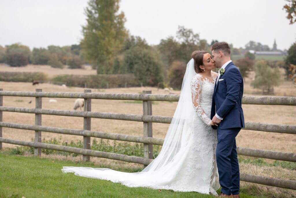 27 bride groom kiss countryside cornfields mythe barn luxury venue leicestershire oxfordshire wedding photography