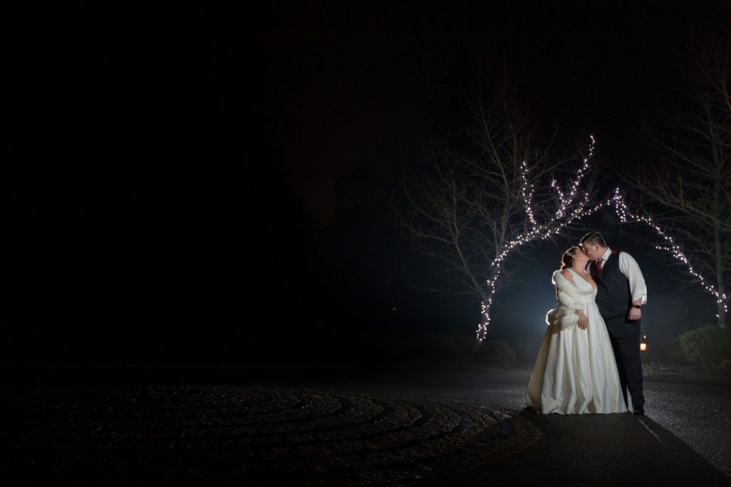 bride groom kiss under christmas fairy lights south lodge hotel west sussex oxford wedding photographers