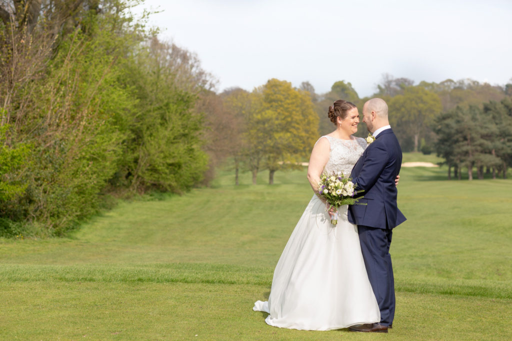 bride groom embrace on golf course oaks farm surrey oxfordshire wedding photography