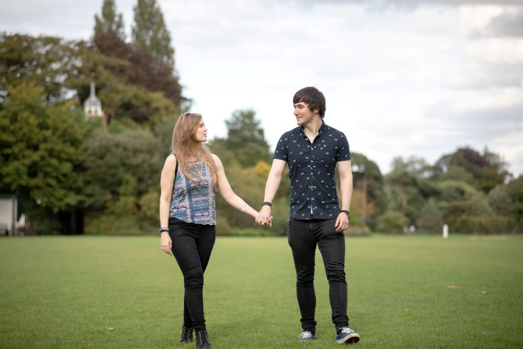 couple hold hands oxford parks cricket field engagement photo shoot oxfordshire wedding photographer