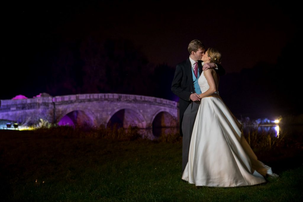 bride groom kiss beside floodlit bridge blenheim palace grounds woodstock oxfordshire wedding photography