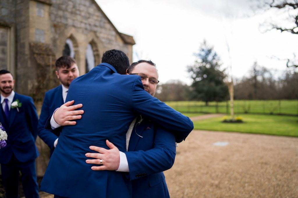 groomsman hugs groom royal chapel windsor great park berkshire oxford wedding photography