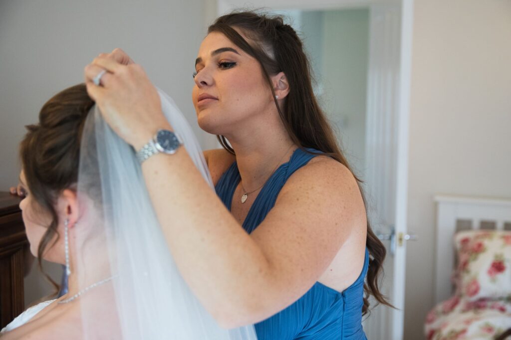 bridesmaid fixes brides veil bridal preparation streatley oxford wedding photographers