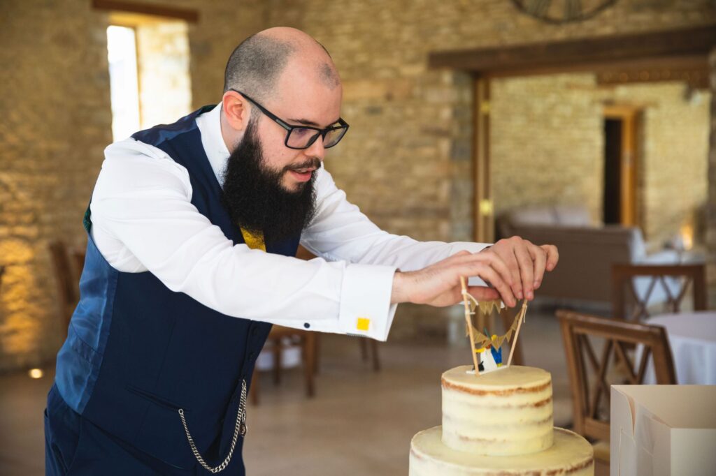 groom places cake top decoration caswell house venue oxford wedding photography