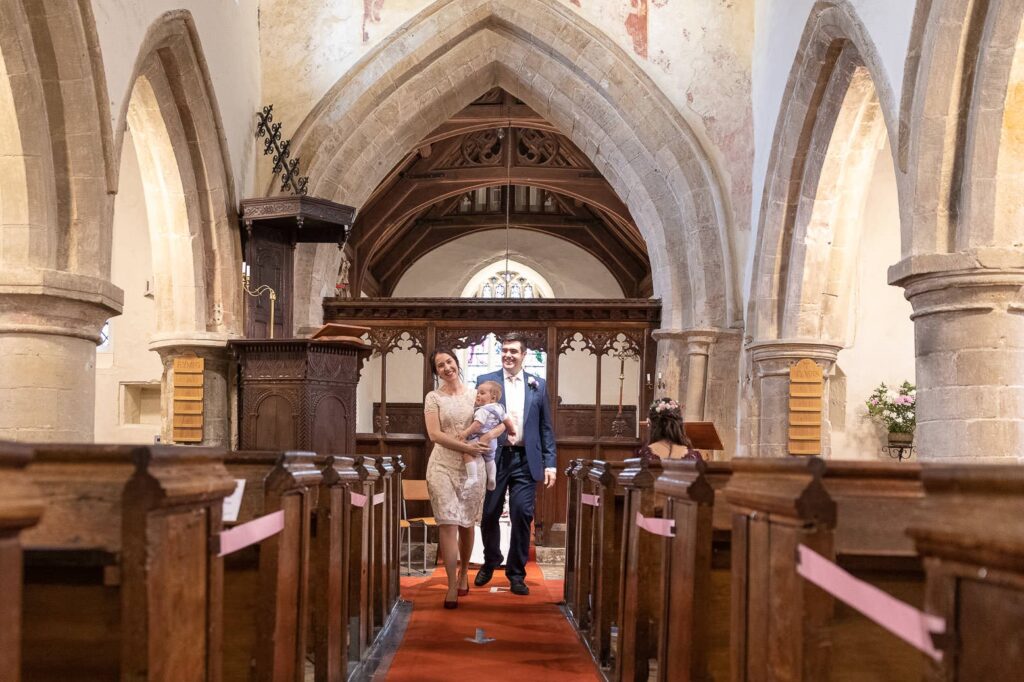 groom bride holding baby aisle walk covid marriage ceremony st nicholas church oxfordshire wedding photography