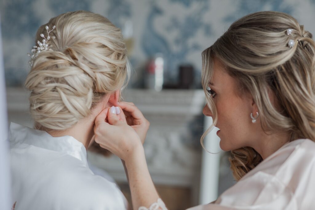 bridesmaid fixes brides earring bridal preparation holdenby northamptionshire oxford wedding photographer