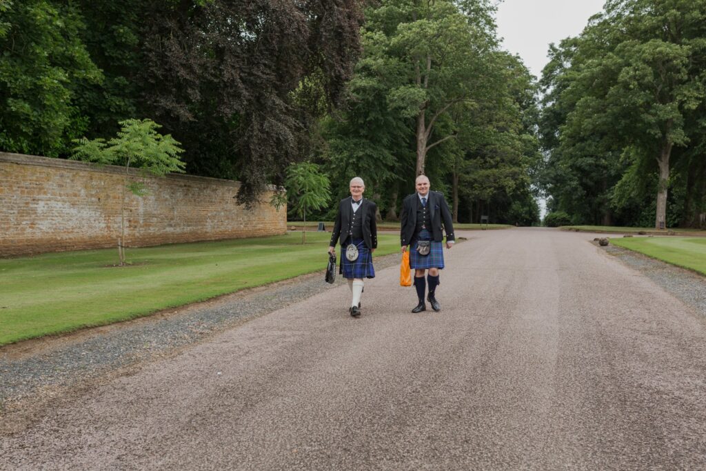 guests arrive wearing kilts holdenby house driveway northamptonshire oxford wedding photography