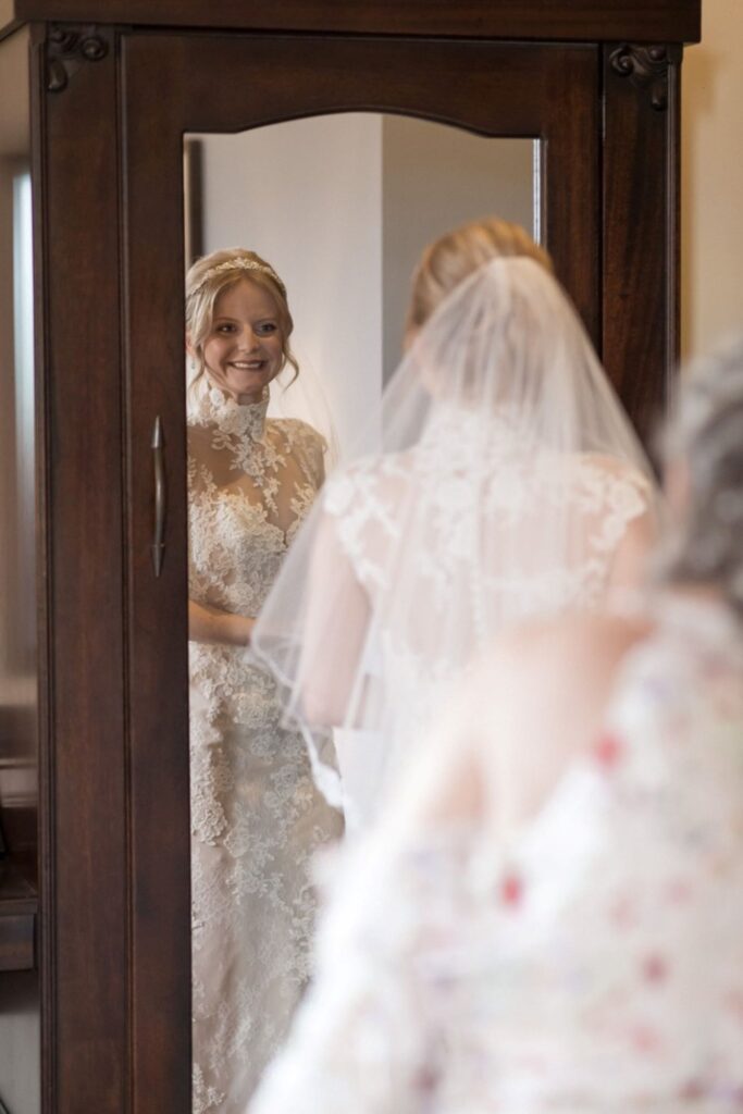 16 smiling brides mirror reflection peckforton castle bridal preparation cheshire oxfordshire wedding photography