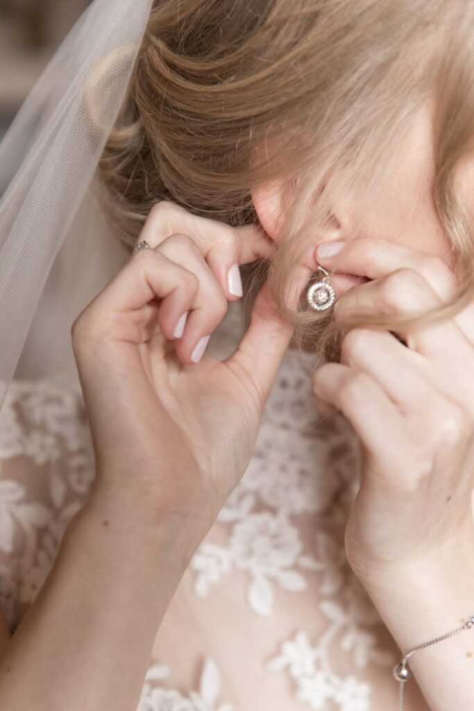 17 bride fastens diamond earring bridal prep peckforton castle cheshire oxford wedding photographers