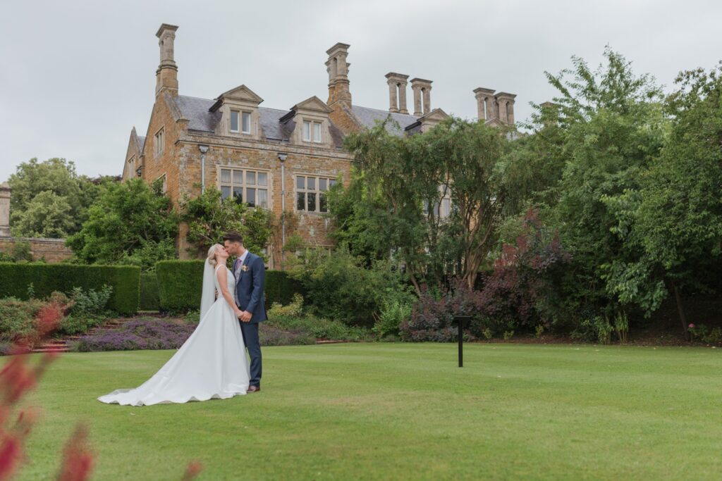 groom kisses bride holdenby house gardens northampton oxfordshire wedding photographers