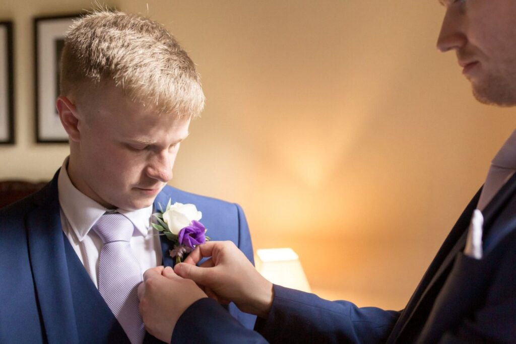 32 groomsman fastens corsage flower groom prep tarporley cheshire oxford wedding photography