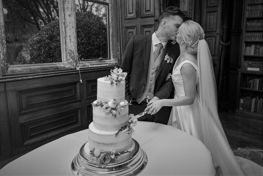 bride groom kiss cake cutting ceremony holdenby house northampton oxfordshire wedding photography