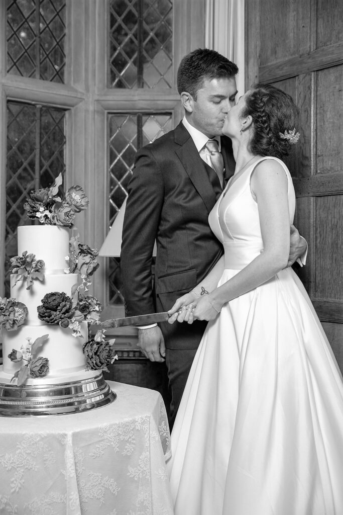 109 groom kisses bride cake cutting ceremony cogmans lane venue surrey oxfordshire wedding photographers
