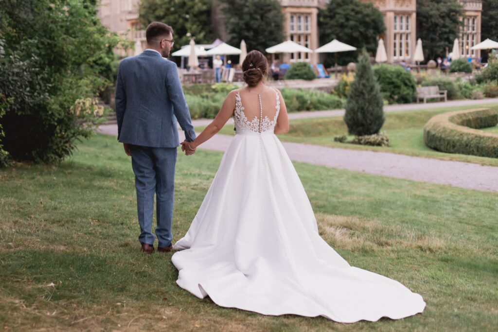 126 bride groom stroll holding hands de vere hotel gardens wotton under edge oxford wedding photographers