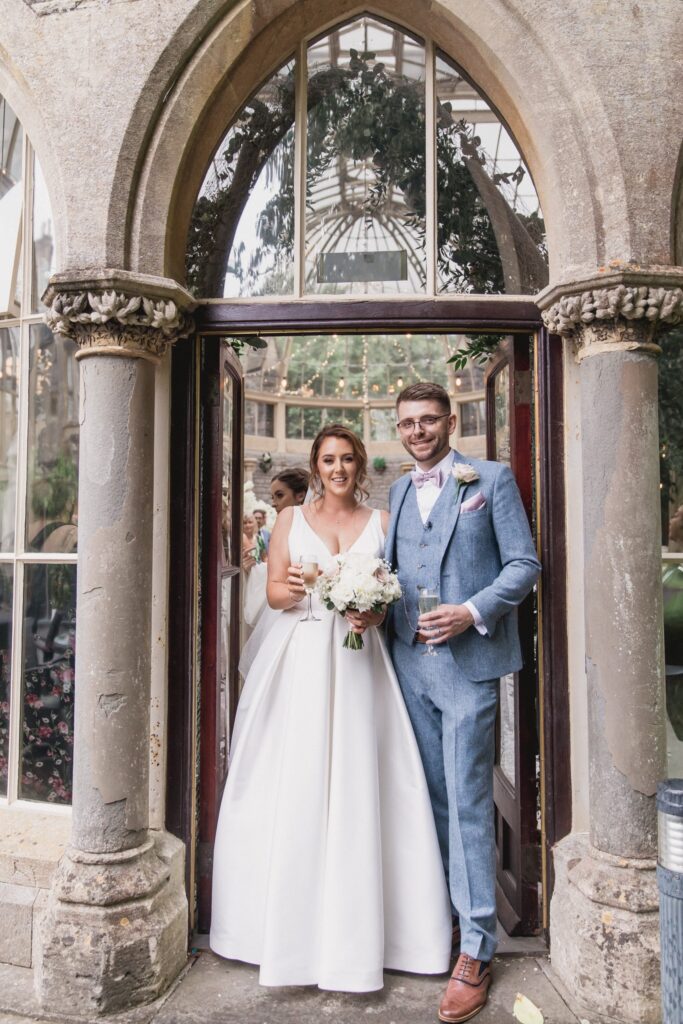 68 bride groom hold champagne glasses de vere hotel wotton under edge oxfordshire wedding photographers