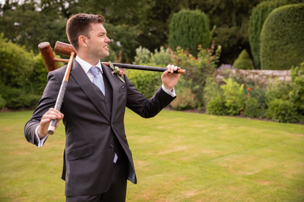 68 groom holds croquet mallets cogmans lane surrey oxford wedding photographer