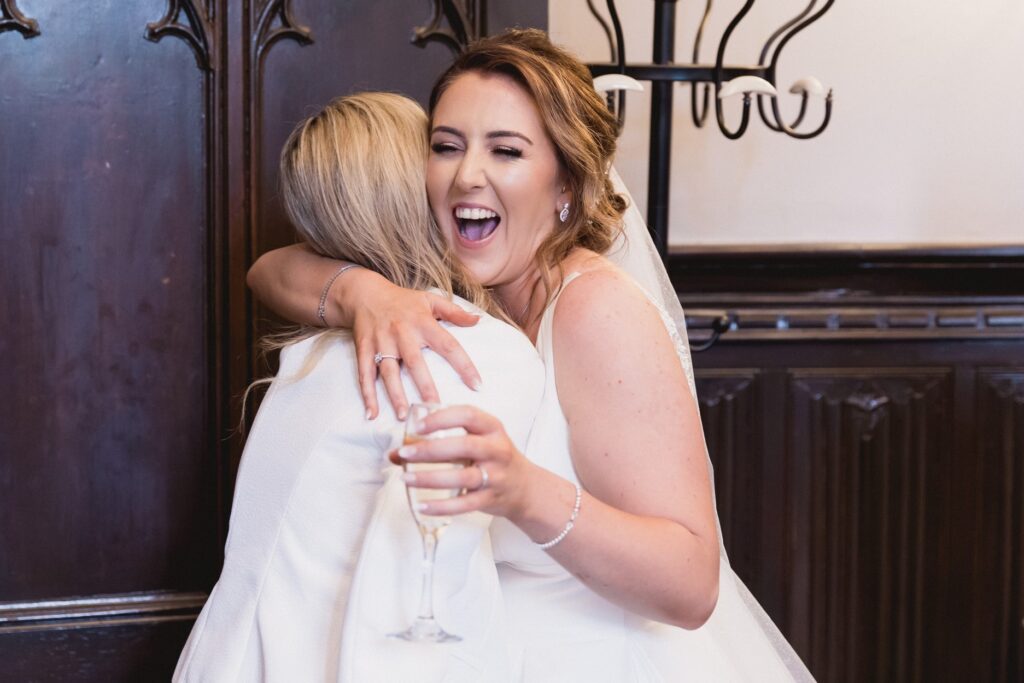 71 laughing bride hugs guest de vere hotel champagne reception wotton under edge oxford wedding photographers