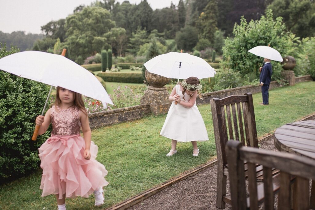 73 flowergirls pageboy shelter under umbrellas de vere hotel reception wotton under edge oxfordshire wedding photographer