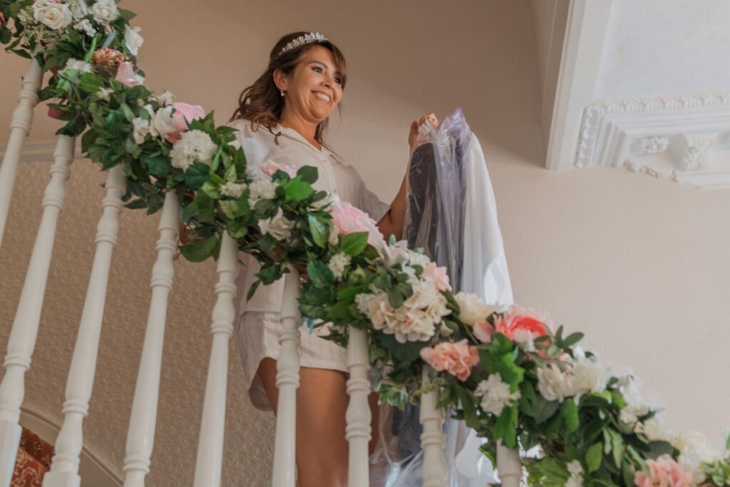 17 bride descends floral decorated staircase london bridal prep oxfordshire wedding photographer