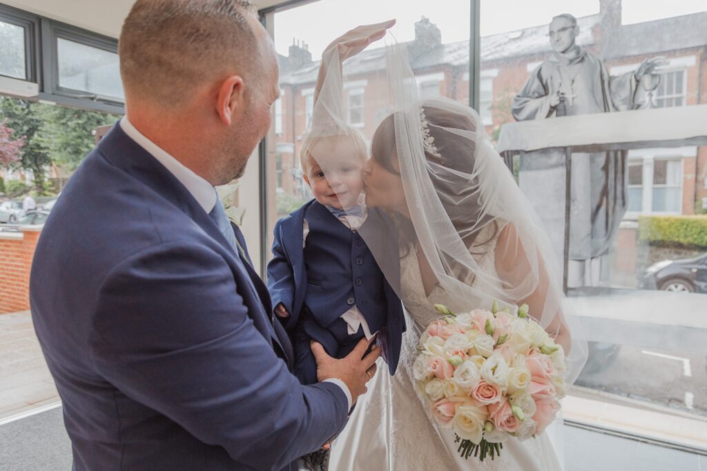 32 veiled bride kisses toddler st peter in chains church north london oxford wedding photographer
