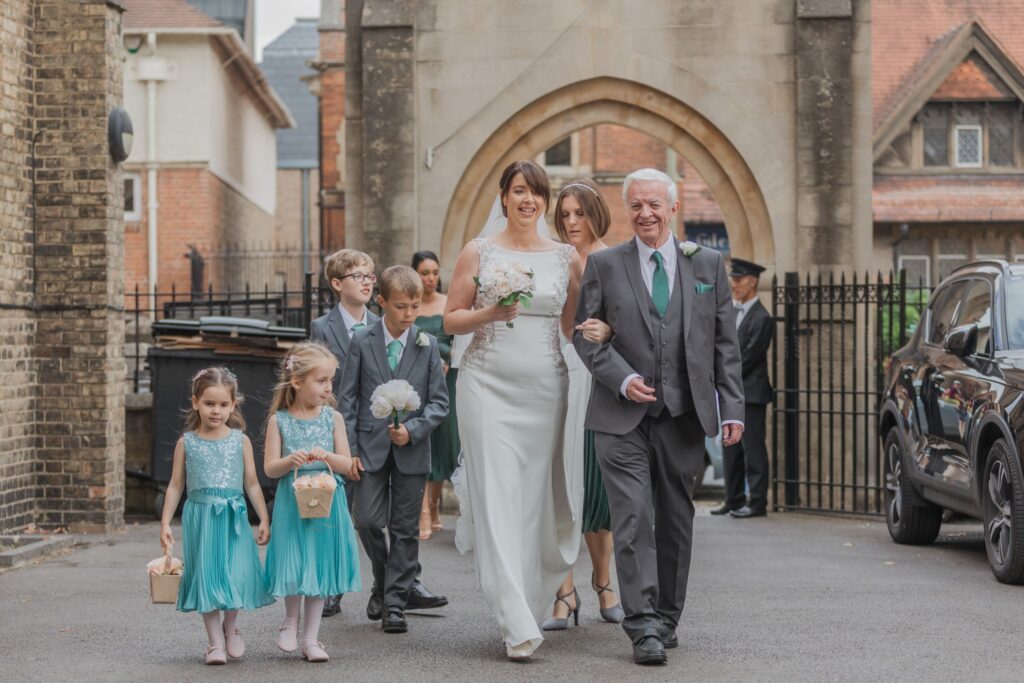 29 bridal party enter church courtyard oxford oratory wedding s r urwin photographers oxfordshire
