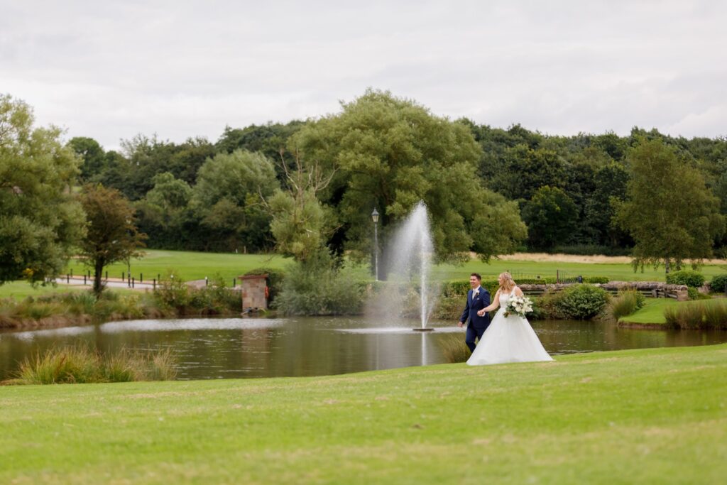 53 bride groom stroll past fountain horsley lodge golf club grounds derby oxford wedding photographers