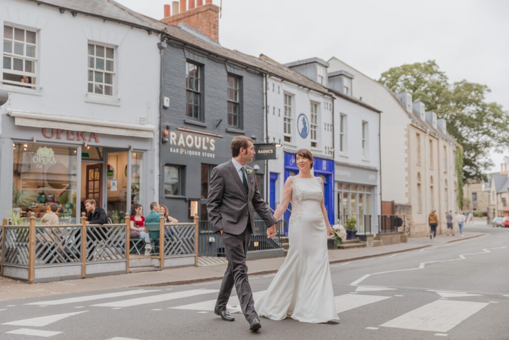 64 bride groom cross oxford city centre road holding hands oxfordshire wedding photography