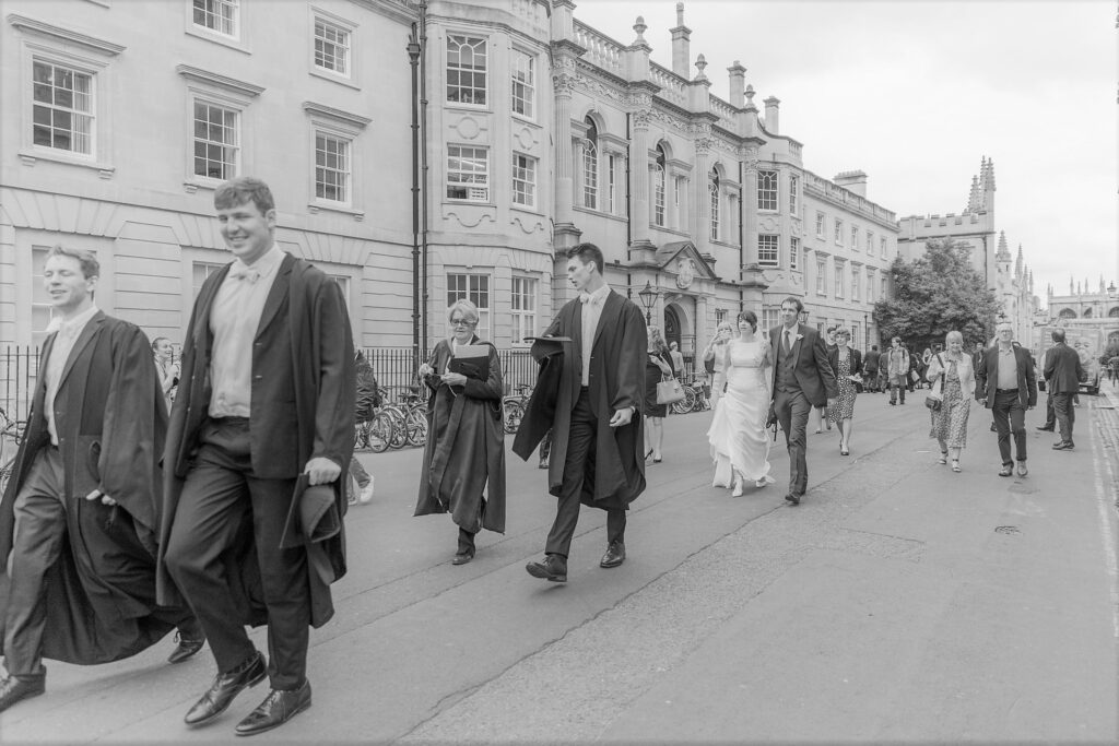 67 bride groom walk with gowned academics broad street oxford oxfordshire wedding photographers