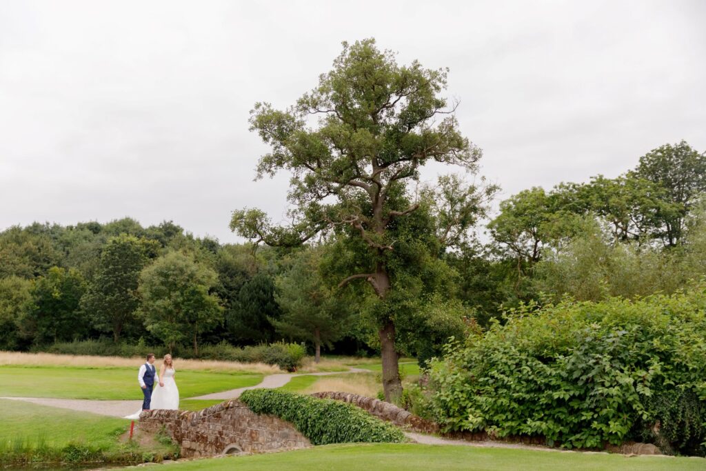 86 groom bride hold hands horsley lodge golf club grounds derbyshire oxford wedding photography
