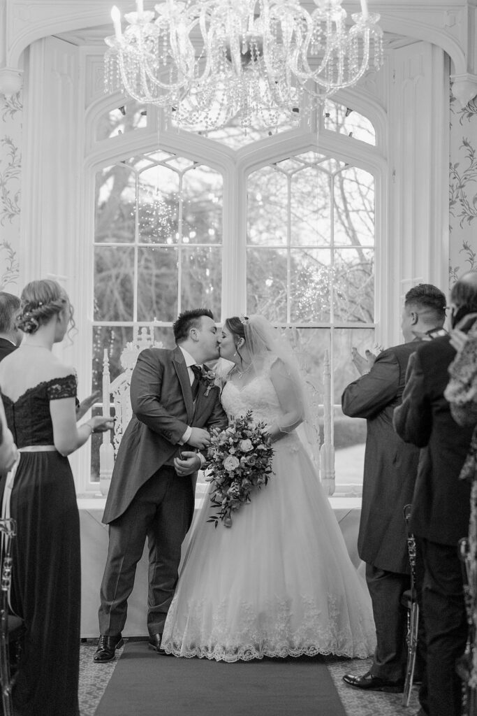 82 guests applaude kissing bride groom shrewsbury marriage ceremony oxfordshire wedding photographer