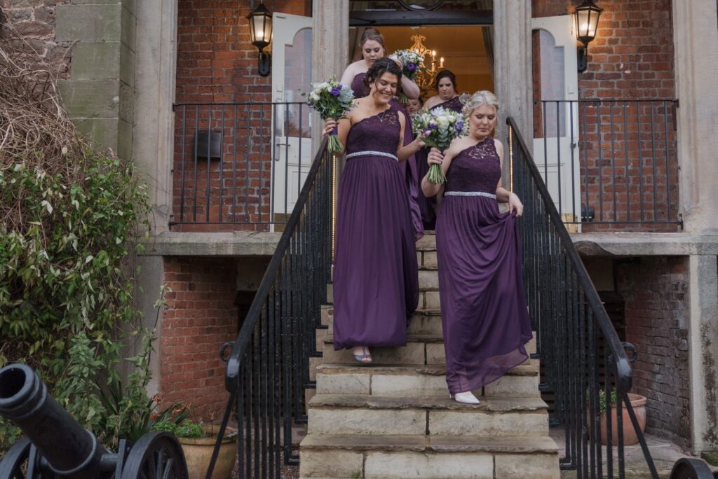 86 bridesmaid descend steps holding bouquets shrewsbury oxford wedding photographers