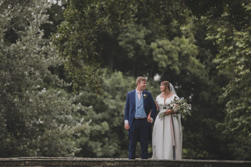 106 bride groom hold hands thorganby venue garden bridge north yorkshire oxfordshire wedding photographers