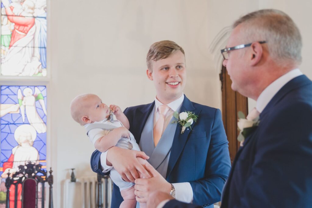 54 groom holds baby thorganby venue north yorkshire oxfordshire wedding photographer