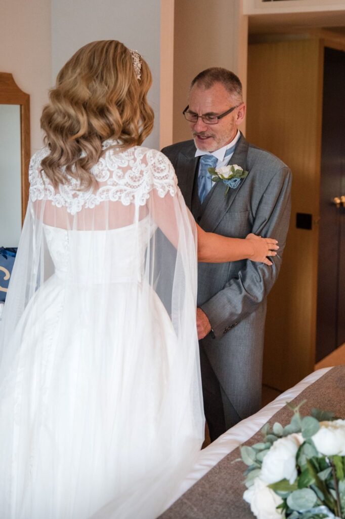 33 father of bride admires daughters gown voco oxford thames oxfordshire wedding photographer