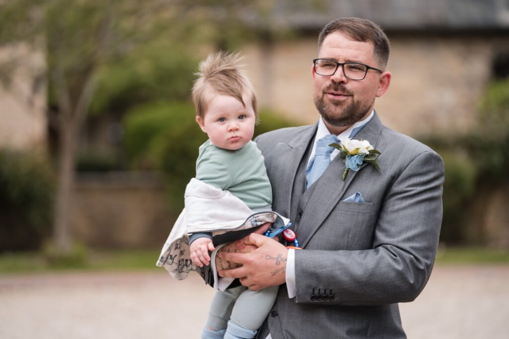 37 bestman holds toddler ihg hotel grounds sandford oxford oxfordshire wedding photographer