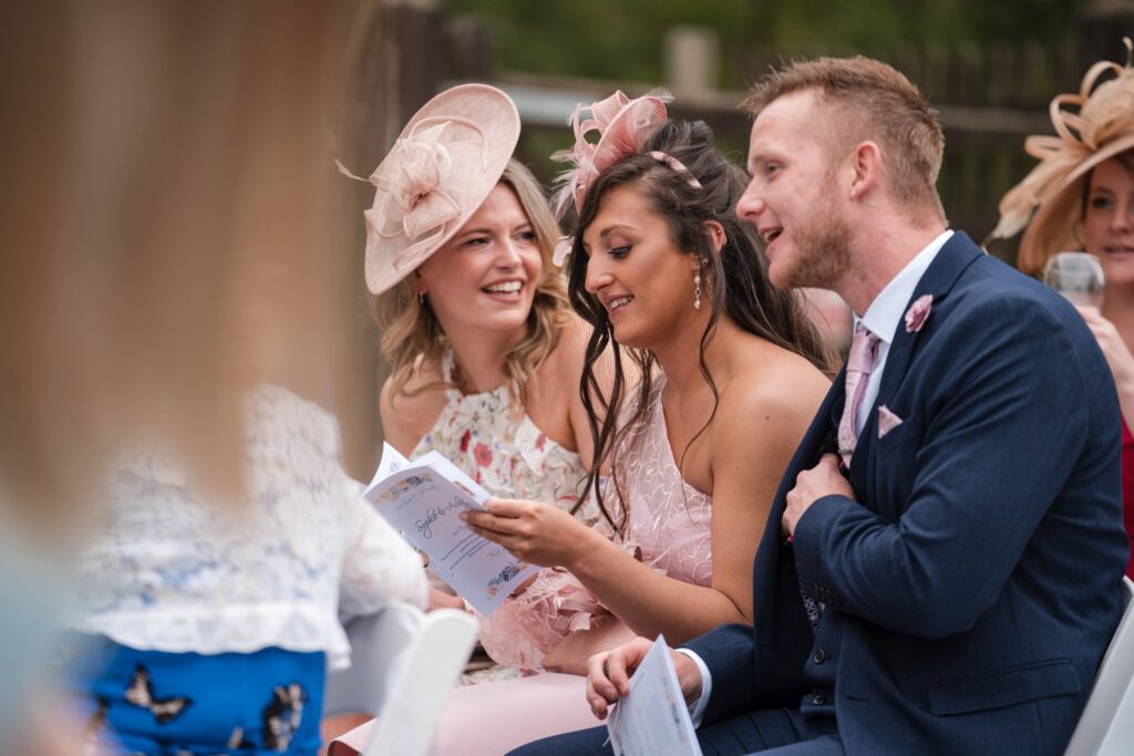 42 smiling guests awaiting bride ihg hotel outdoor ceremony sandford oxford oxfordshire wedding photography