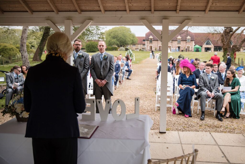 54 celebrant awaits brides arrival outdoor ceremony ihg hotel grounds sandford oxford oxfordshire wedding photography