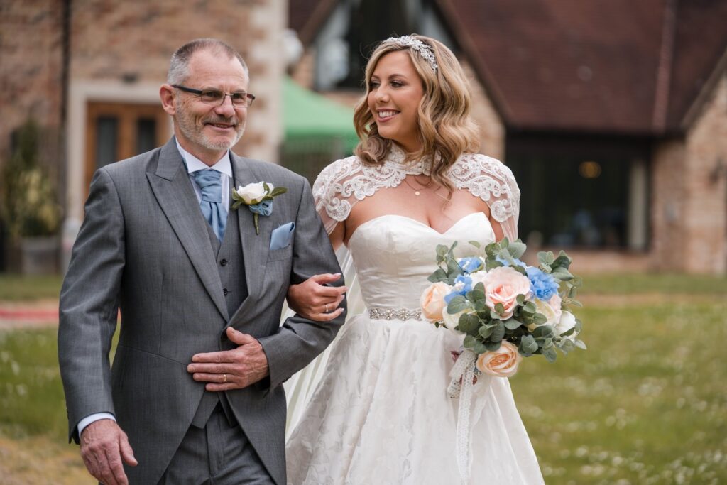 56 smiling bride links fathers arm ihg hotel outdoor ceremony sandford oxford oxfordshire wedding photographers
