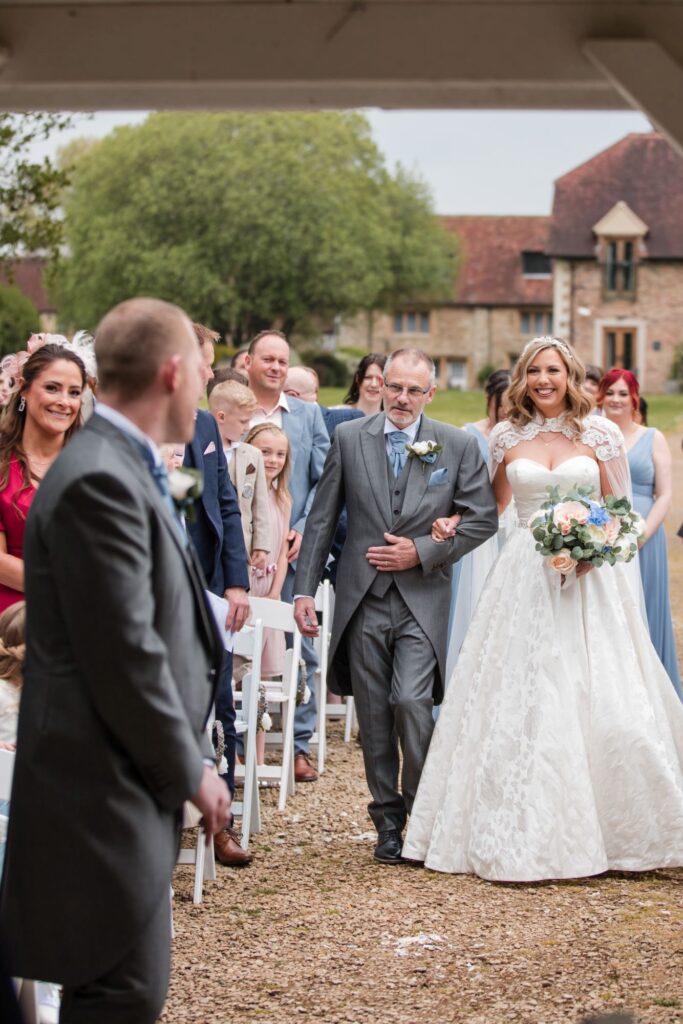 60 groom turns bride smiles ihg hotel outdoor ceremony sandford oxford oxfordshire wedding photograph