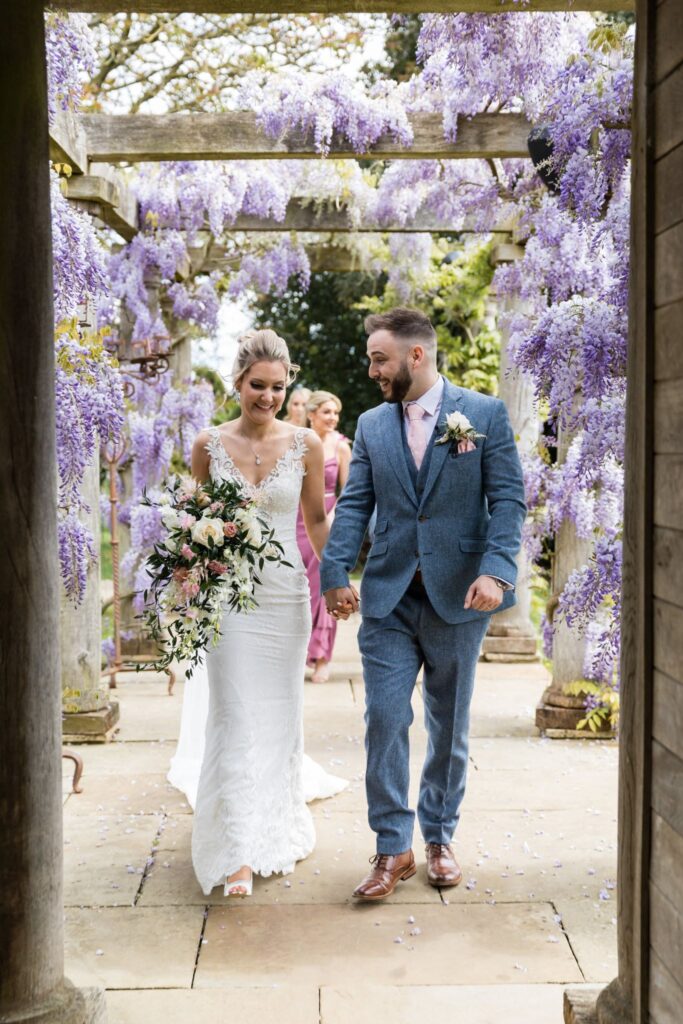 63 bride groom walk under wysteria pergola euridge manor chippenham wiltshire oxfordshire wedding photographers