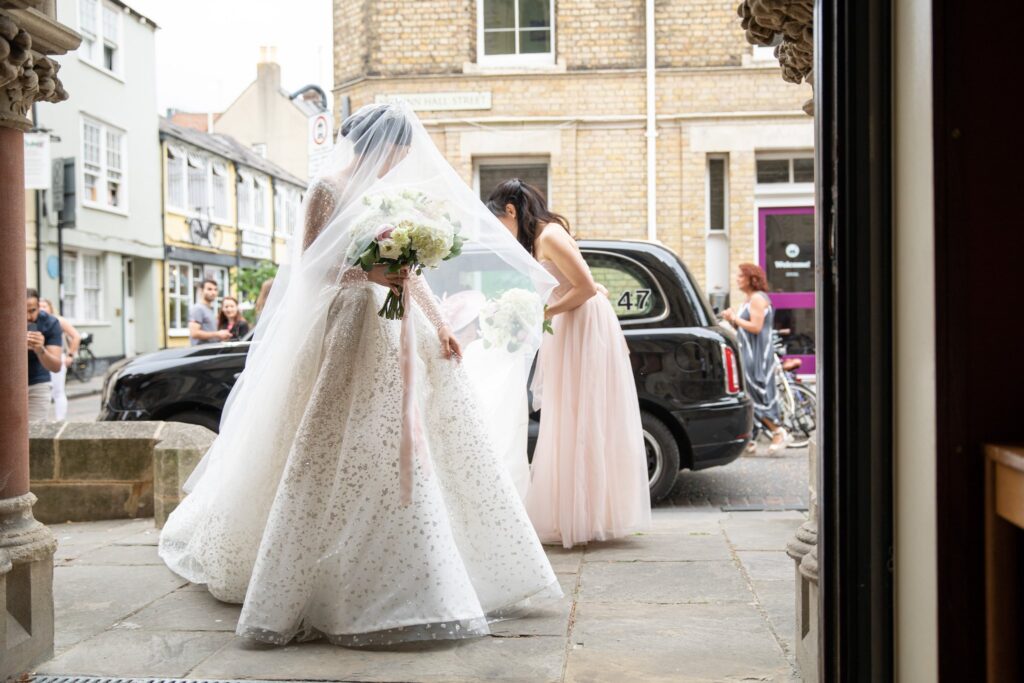 04 bridesmaid staightens brides gown wesley memorial church oxford oxfordshire wedding photographer