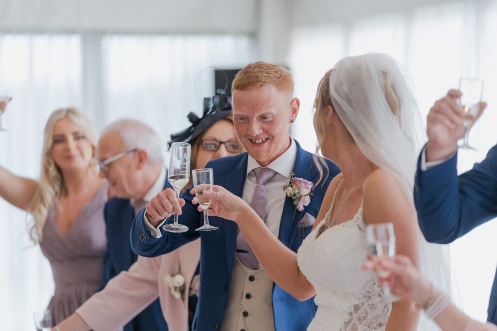 116 bridal party raise champagne glasses cotswolds hotel golf and spa chipping norton oxfordshire wedding photographer