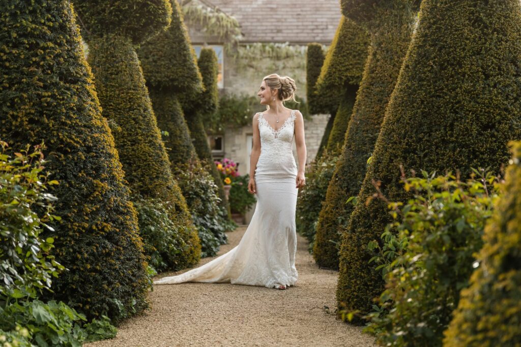 129 smiling bride strolls euridge manor topiary garden chippenham wiltshire oxfordshire wedding photographers