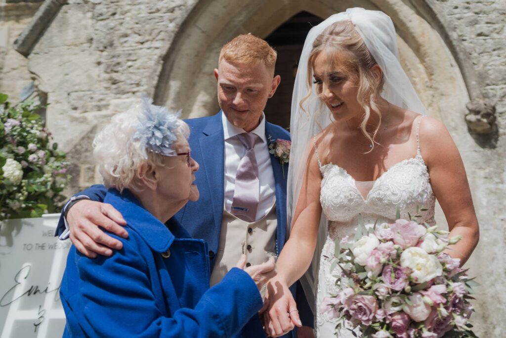 70 elderly guest meets bride groom headingto quarry parish churchyard oxford oxfordshire wedding photographer