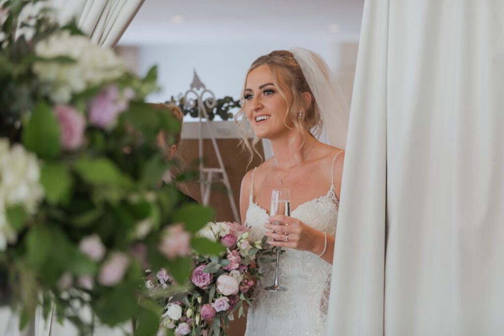 76 bride holds champagne glass cotswolds hotel chipping norton oxfordshire wedding photographers