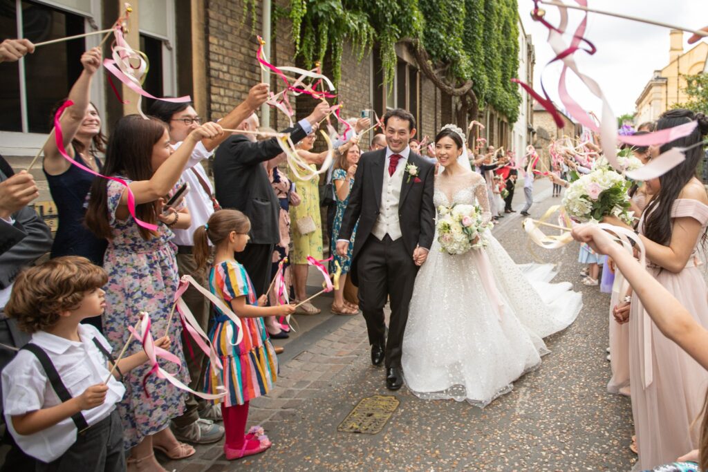 bride grooms enjoy guests ribbons parade wesley memorial church marriage oxford oxfordshire wedding photography