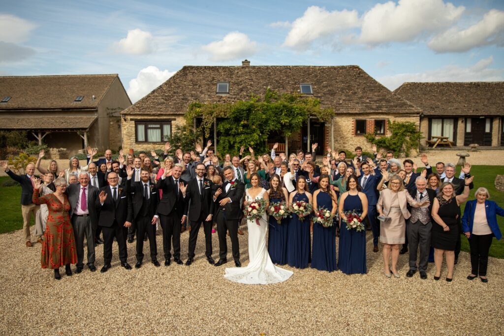 06 bridal party guests wave the great tythe barn tetbury gloucestershire oxford wedding photographer