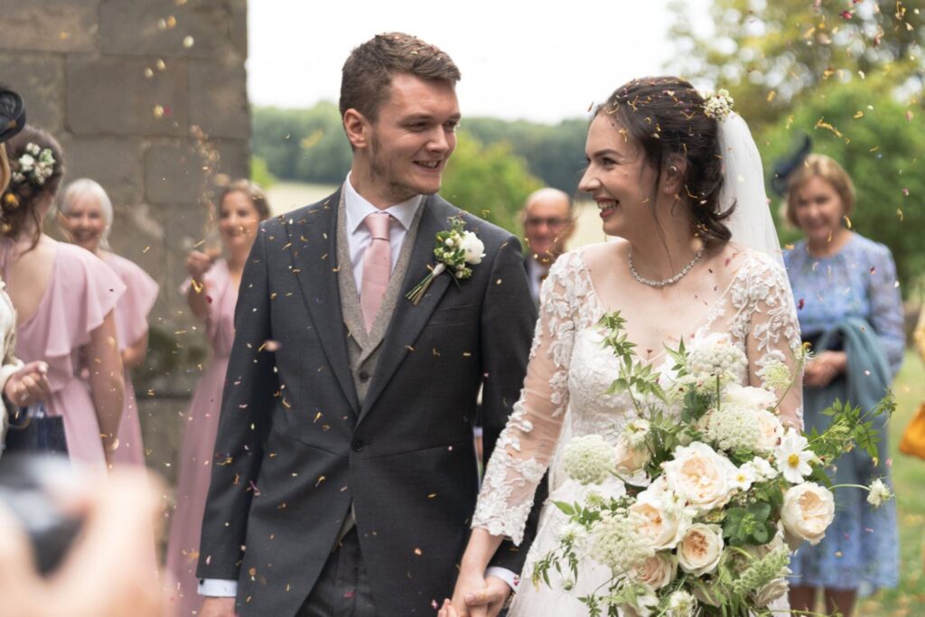 84 smiling bride groom enjoy confetti parade st andrews churchyard leicestershire oxford wedding photographer